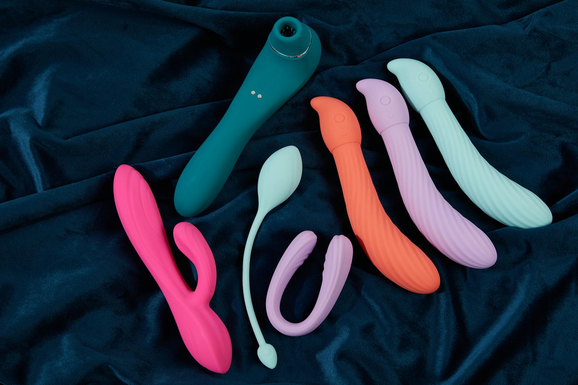 A yellow silicone vibrator surrounded by fresh bananas on a bright yellow background
