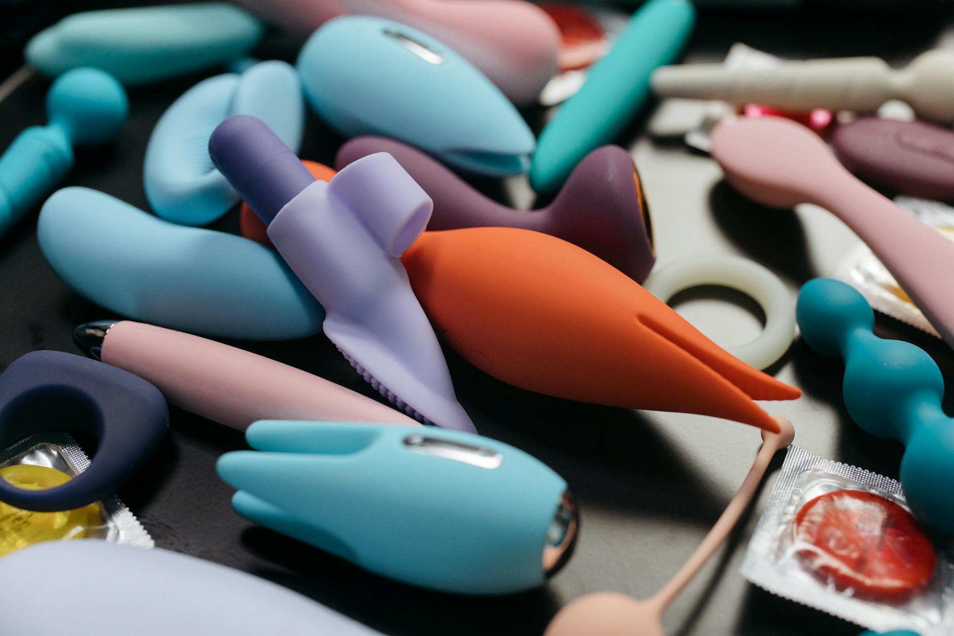 A hand holding a vibrator above a decorative glass bowl, demonstrating toy placement