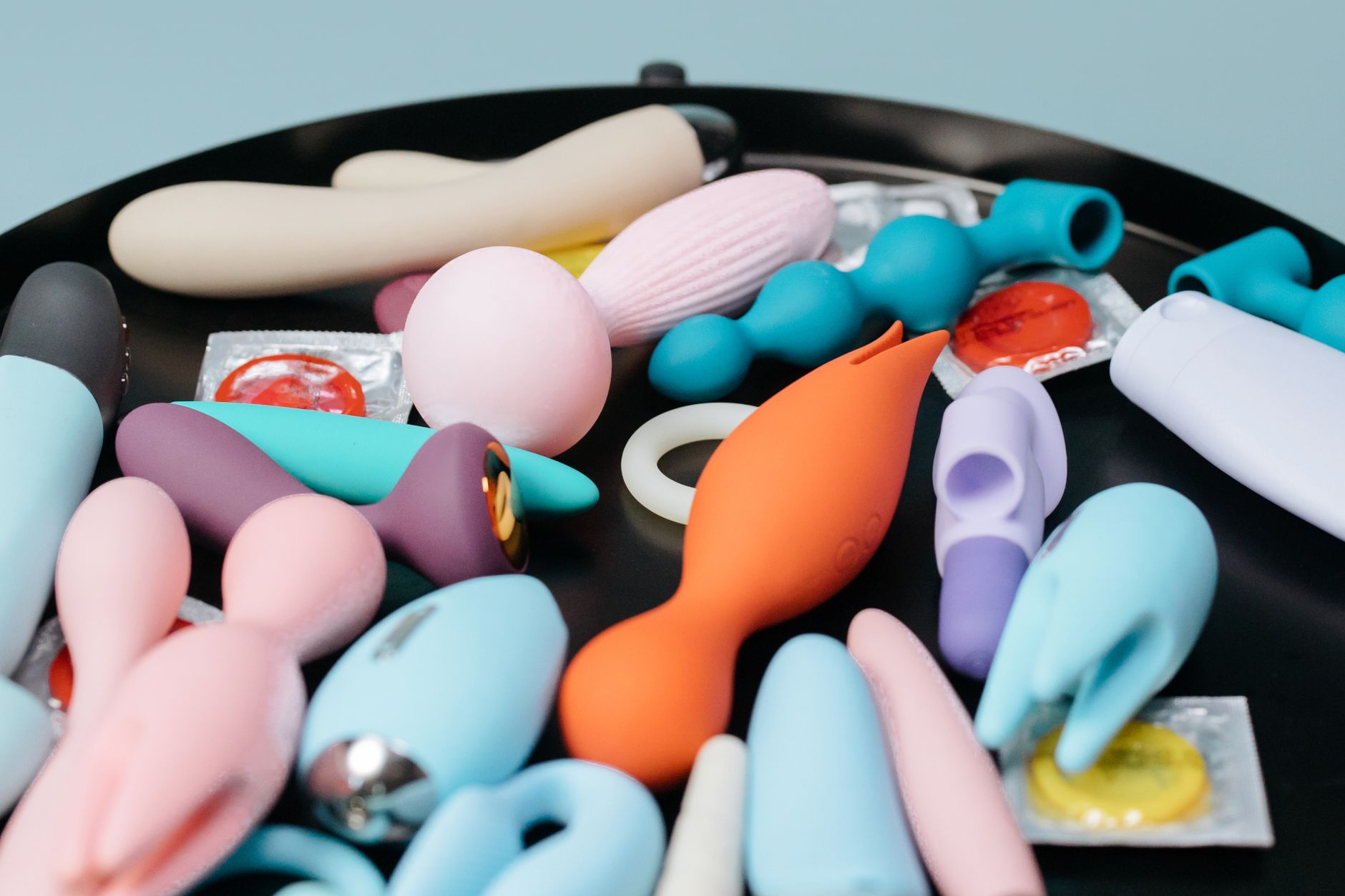 Colorful vibrators arranged on a black tray showing diverse shapes