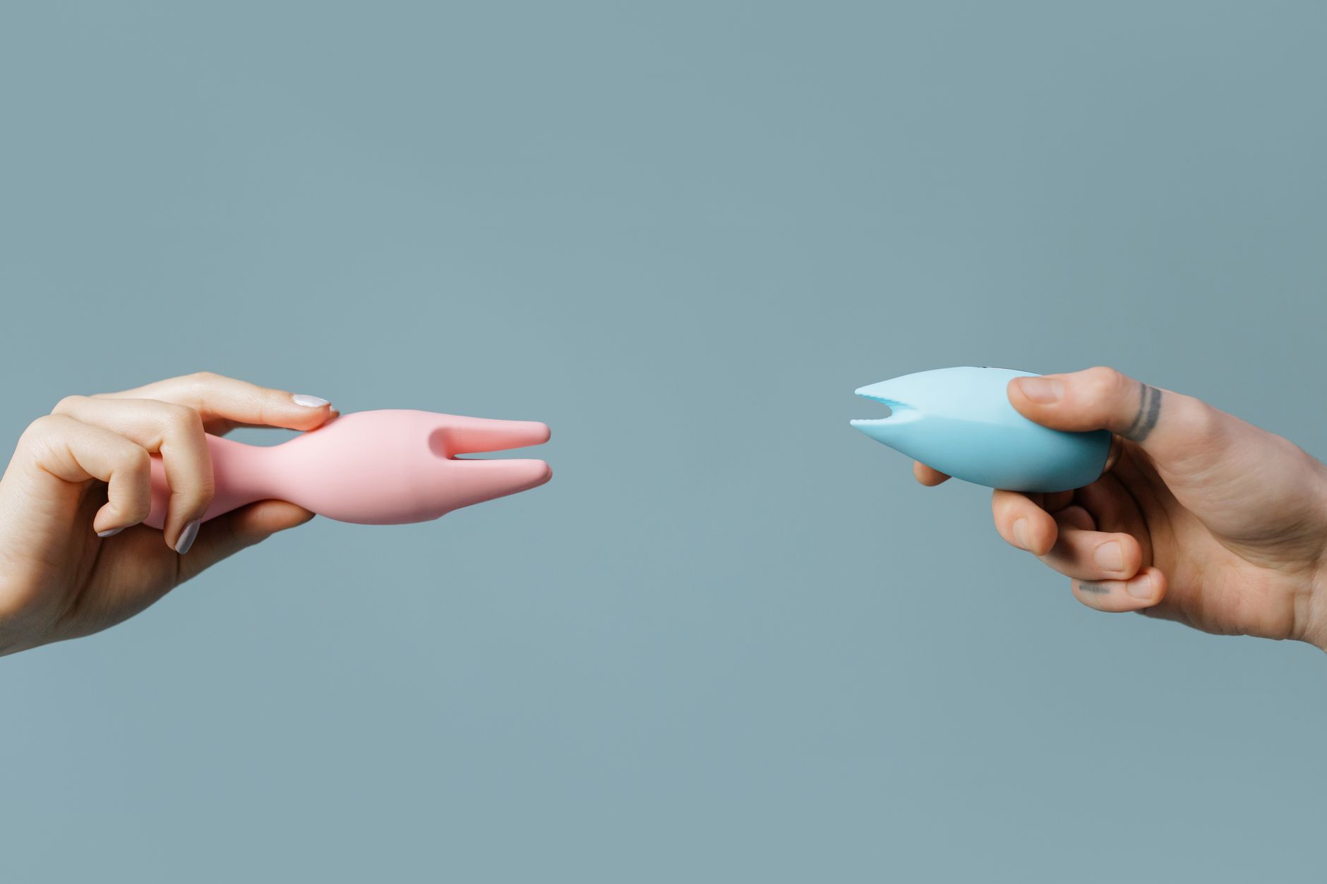 A hand holding an orange vibrator against a minimalistic purple backdrop, symbolizing modern sensuality and self-discovery