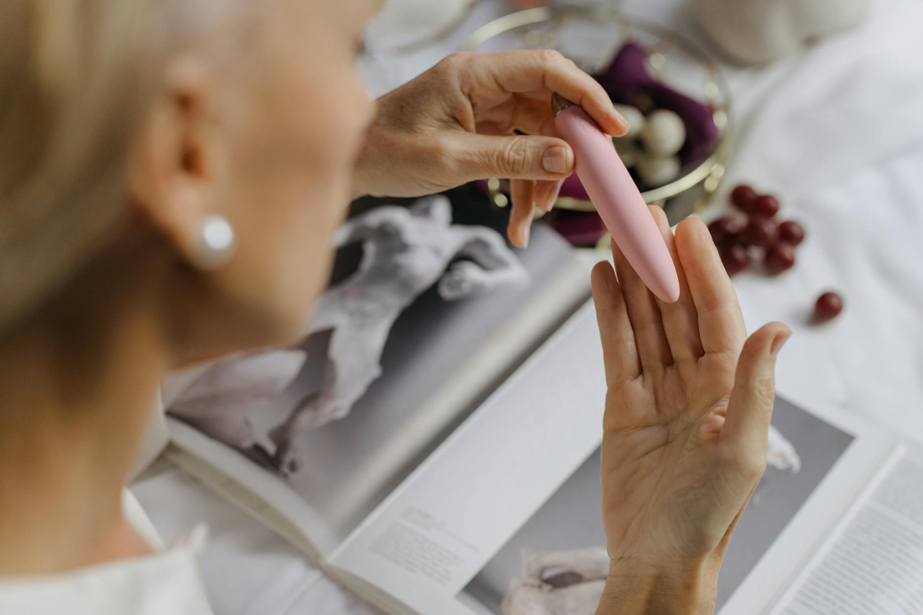 Close-up of a hand holding a pink vibrator, representing intimate self-discovery and pleasure during recovery