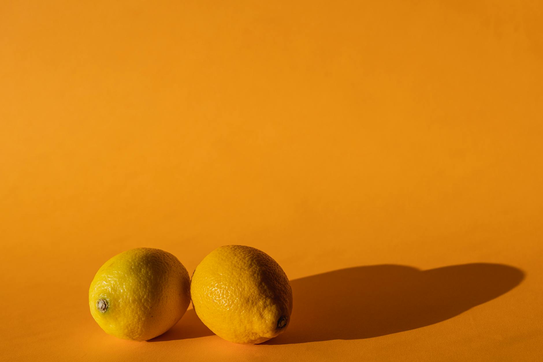 Bright ripe lemons on a yellow background in studio lighting